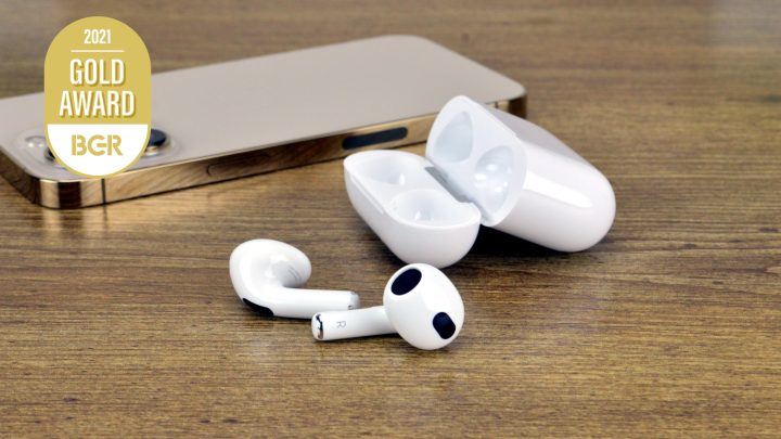 Apple AirPods 3 on a table next to an iPhone 13 Pro