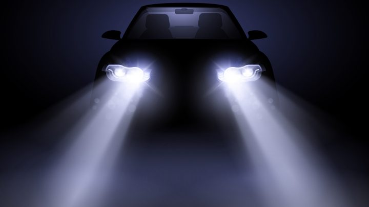 A car with LED headlights shining directly at the camera