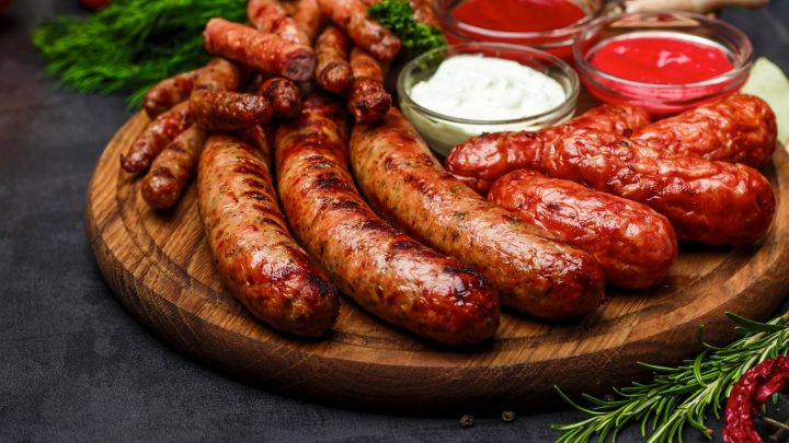 Various types of sausages grilled on a platter.