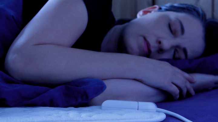 Woman sleeping on an electric heated blanket.