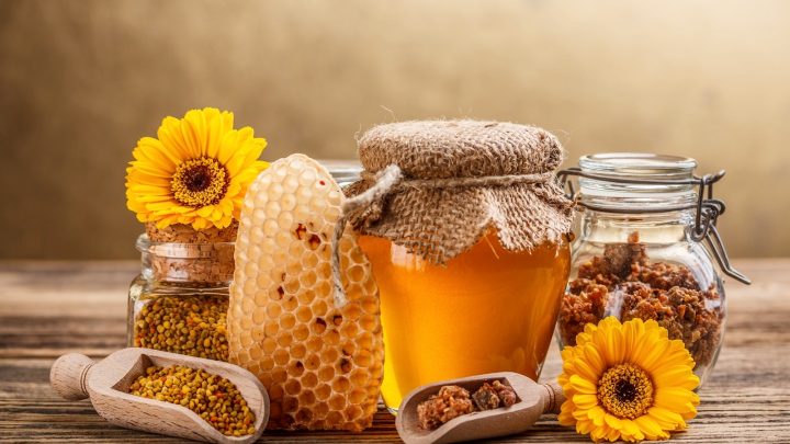 Honey, honeycomb, pollen, and propolis products on a table