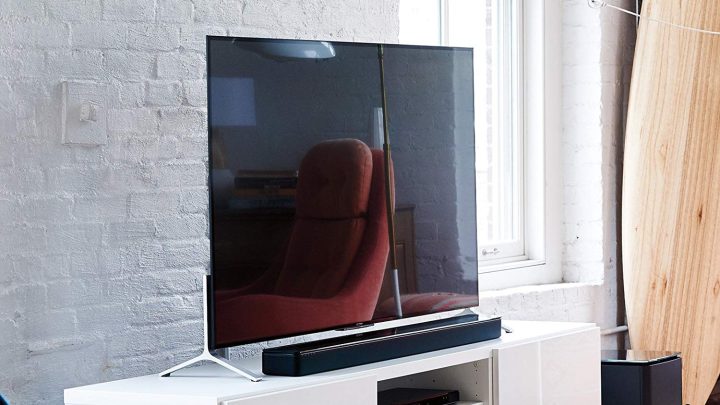 A Bose TV soundbar speaker in front of a smart TV