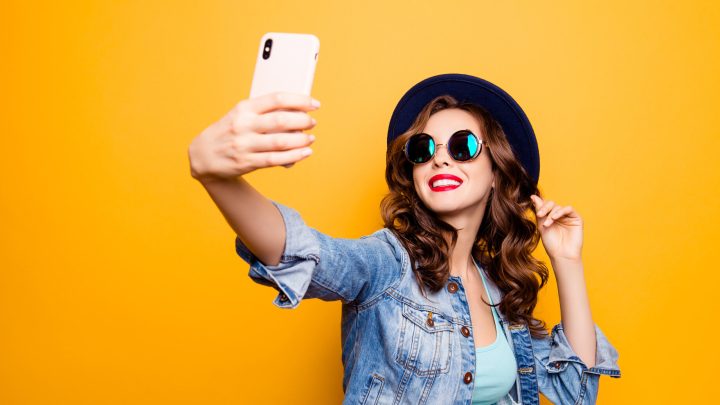 A girl is shown taking a selfie with a smartphone