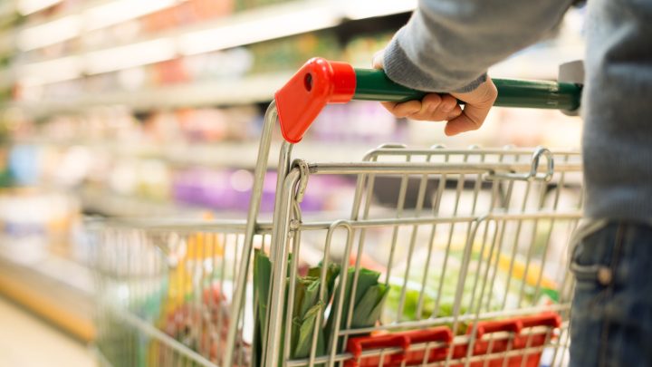 Close-up of a customer pushing a grocery store shopping cart
