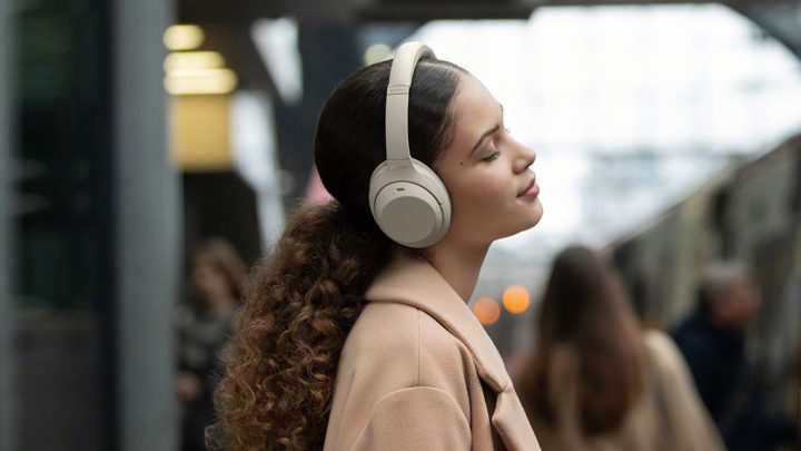 A woman listening to music on her Sony WH1000XM4 Wireless Noise Cancelling Headphones
